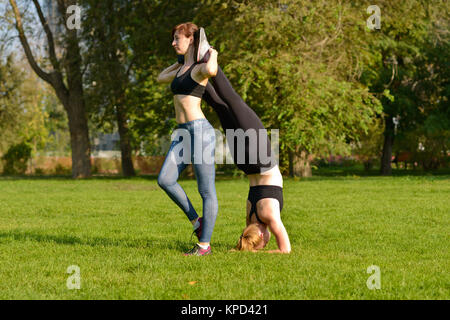 Zwei Mädchen sind einander helfen, die Muskeln zu wärmen, bevor Übungen Stockfoto