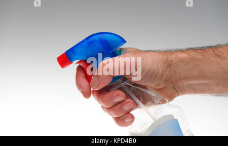 Nahaufnahme der Hand sprühen Dettol anti-bakterielle Oberflächenreiniger Spray flasche auf weißem Hintergrund. Hat für Konzepte verwendet. Stockfoto