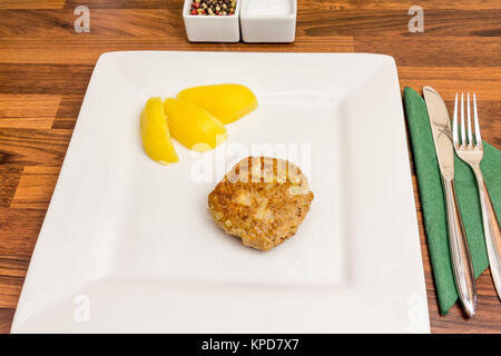 Ein frisch gebratenes frikadeller auf einem weißen Teller mit Kartoffeln und Besteck Stockfoto