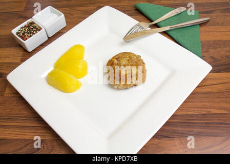 Ein frisch gebratenes frikadeller auf einem weißen Teller mit Kartoffeln und Besteck Stockfoto