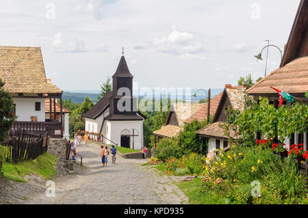 Besucher schlendern Sie entlang des Kossuth Street in der UNESCO World Heritage Village - Holloko, Ungarn Stockfoto