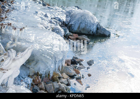 Felsen mit Eis im Winter See eingefroren Stockfoto