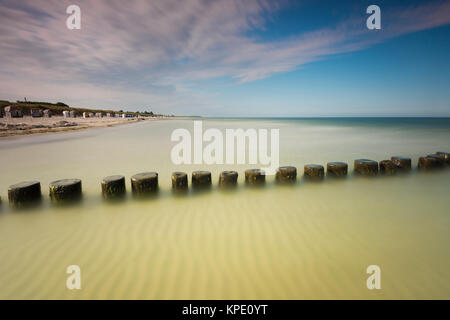 Ostsee mit Zeichnung Wolken im Sonnenuntergang mit Abend rot und Moody Abendlicht. Strand mit Leisten und Wellen sowie schöne Wolken. Stockfoto