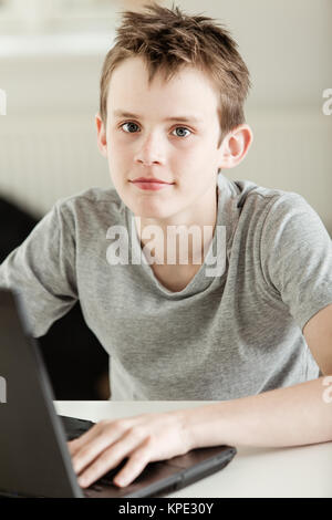 Junge Arbeiten auf seinem Laptop, Kamera Stockfoto