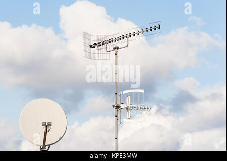 TV-Antenne und Satellitenschüssel vor blauem Himmel Stockfoto