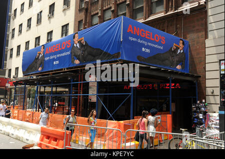 NEW YORK, NY - 07. Juli: American während Bau bleibt auf der Fassade des Theaters im Voraus von Colbert's Debüt, Nachbar Angelo's Pizza hat unter Gerüst versteckt. Es gibt jetzt eine massive Zeichen auf der Frontseite der Baustelle, zeigt den Namen Angelo's Pizza durch zwei lounging Stephen Colberts flankiert, breit lächelnd mit einer Scheibe in der Hand am 7. Juli 2015 in New York City People: Stephen Colbert Stockfoto