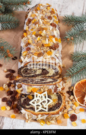 Hausgemachte Mohn Kuchen und Niederlassungen auf rustikalen Board, Dessert und Deko für festliche Weihnachtszeit Fichte, aufgerollt traditionelle polnische Poppy p Stockfoto