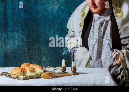 Ein Mann bricht am Samstag festliches Brot Hausgemachte challah am Schabbat Stockfoto