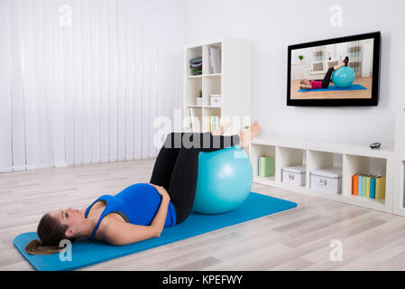 Junge schwangere Frauen tun Workout Stockfoto