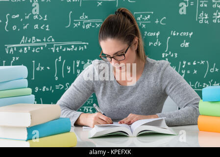 Frau Schreiben mit Stift in Buch Stockfoto