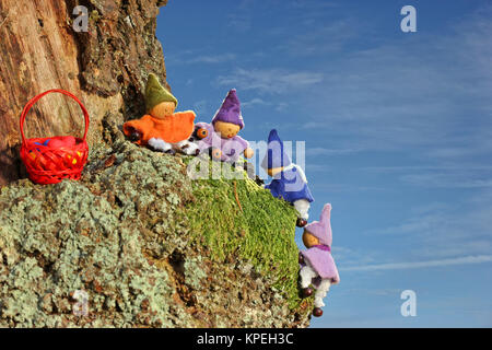 Vier kleine Gnome mit Ostereiern klettern auf einen Baum Stockfoto