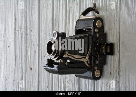 Alte Kamera hängt an den alten weißen Holzwand Stockfoto
