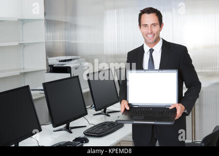 Glücklich im mittleren Alter Geschäftsmann mit Laptop Stockfoto