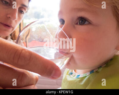 Baby Trinkwasser von der Mutter hand Stockfoto