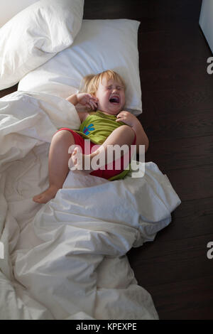 Baby schreien auf Bettwäsche, Stockfoto