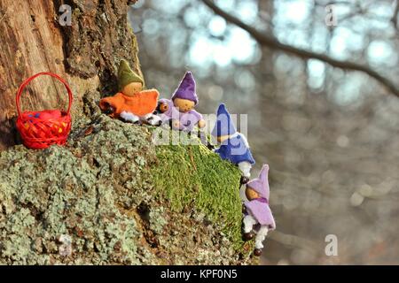 Vier kleine Gnome mit Ostereiern klettern auf einen Baum Stockfoto