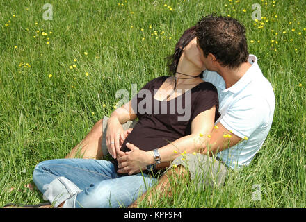 Liebespaar Kuesst Sich in der Wiese - Liebe Paar küssen auf Wiese Stockfoto