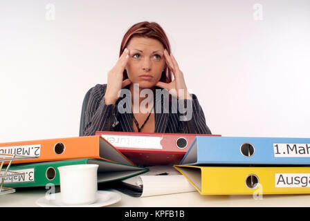 Gestresste, Ueberforderte Geschaeftsfrau bin Schreibtisch - gestresst, überfordert Geschäftsfrau im Büro Stockfoto