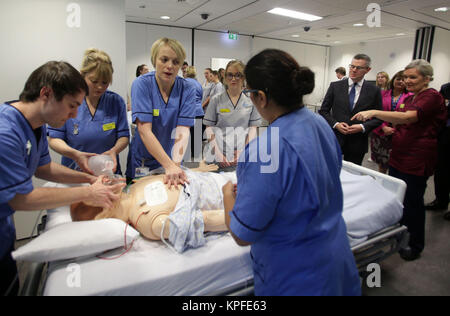 Schottische Finanzminister Derek Mackay (Zweiter von rechts) Uhren einer Lehrveranstaltung auf Cardio-pulmonalen Reanimation (CPR) in einer simulierten Gemeinde Umwelt am Lehren und Lernen Zentrum, Queen Elizabeth University Hospital, Glasgow. Stockfoto