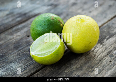 Zwei Limetten in Scheiben geschnitten und auf hölzernen Tisch Stockfoto