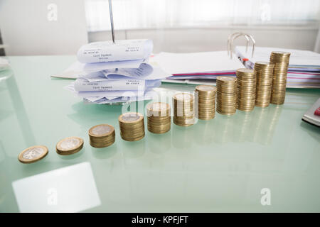 Stapel von Münzen mit Papier Nagel auf Schreibtisch Stockfoto