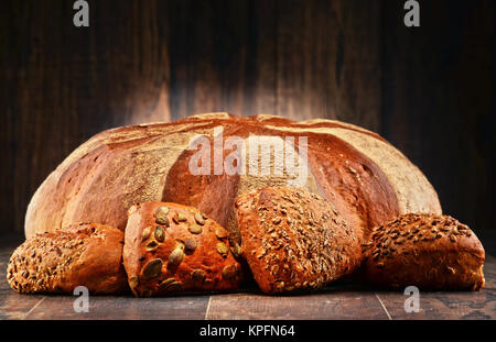 Zusammensetzung mit großen Laib Brot und vier Rollen Stockfoto