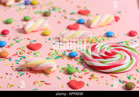 Bunte Bonbons auf rosa Hintergrund, Ansicht von oben, in der Nähe Stockfoto