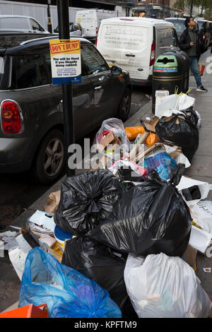 Stapel von Eingesackt Müll liegt auf der Straße unter einem Warnzeichen für illegalen Dumpings, der daraus resultierenden Geldstrafen und Strafverfolgung, am 12. Dezember 2017 in London, England. Stockfoto