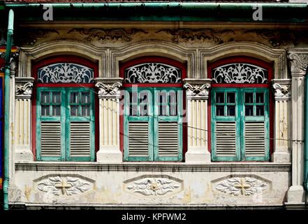 Traditionelle Singapur shop Haus mit grünen Fensterläden aus Holz und kunstvollen Steinmetzarbeiten im historischen Little India Stockfoto