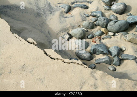 Nahaufnahme von Felsen und Risse in den Sand zu Gonubie Beach, East London Stockfoto