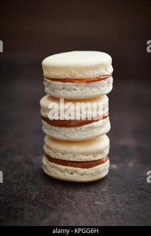 Drei Macarons mit Caramell füllen Stockfoto