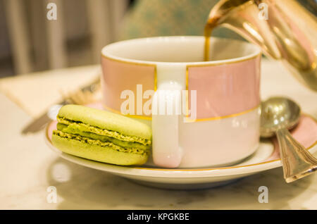Morgen Tasse Kaffee Kuchen Macaron und Blumen auf hellem Hintergrund von oben schöne Frühstück Stockfoto