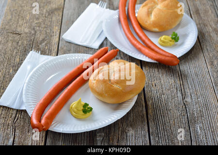 Deutsche Street Food: Heiße Debreziner Würstchen mit würzigen Senf und eine neue Rolle auf ein Papier Platte Stockfoto