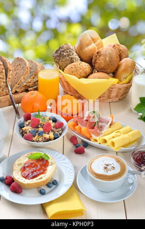 Draußen serviert Ihnen im Sommer das Frühstück mit einer Tasse Cappuccino und eine große Auswahl an Speisen Stockfoto