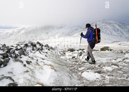 Walker in Richtung Hart-crag von Dove Crag unter winterlichen Bedingungen, Lake District, Cumbria, Großbritannien Stockfoto