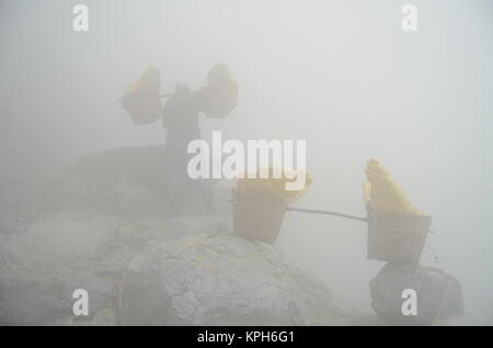 Der schwefel Miner in Kawah Ijen Durchführung der Schwefel in der Mitte von toxischen und blocken Schwefeldioxid. Stockfoto