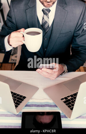 Portrait Professional Business Mann mit Kaffee arbeiten mit mehreren Geräten verbunden zu bleiben Stockfoto