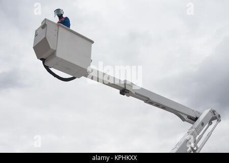 Ein Elektriker in Schützende Uniform arbeitet auf isolierte Antenne Plattform, die sicher auf elektrische Stromleitungen zu arbeiten. Elektriker ist ein Dummy. Stockfoto