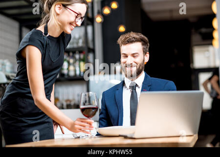 Geschäftsmann mit Kellnerin im Restaurant Stockfoto