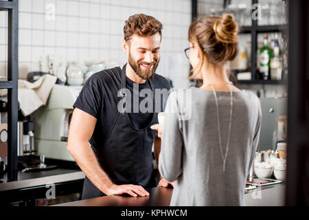 Barista mit Client im Cafe Stockfoto