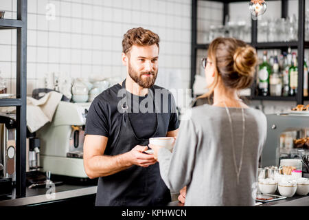 Barista mit Client im Cafe Stockfoto