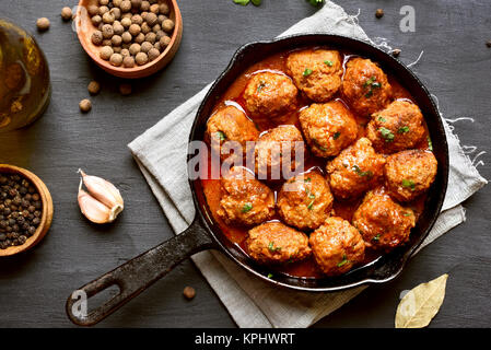 Hackfleischbällchen mit Tomatensauce in gusseisernen Pfanne. Ansicht von oben, flach Stockfoto