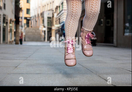 Mädchen springen mit rosa satin spitze Stiefel Stockfoto