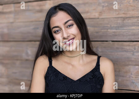 Portrait einer jungen lachende Frau mit langen braunen Haaren Stockfoto