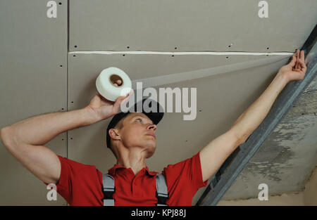 Arbeitnehmer einfügen Net für Nähte zwischen Gipskarton Platten Stockfoto