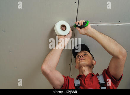 Arbeitnehmer einfügen Net für Nähte zwischen Gipskarton Platten Stockfoto