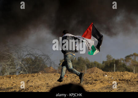 Gazastreifen. Dezember 15, 2017 - Auseinandersetzungen zwischen palästinensischen Demonstranten und israelischen Soldaten in der Nähe der Gaza-Israel Grenzzaun auszubrechen, östlich von al-Bureij palästinensischen Flüchtlingslager, nach Freitag mittag Gebete. Die Palästinenser Demonstranten, die auf dem jüngsten UNS' Anerkennung Jerusalems als Hauptstadt Israels verärgert, warfen Steine auf die israelischen Kräfte, die an ihnen feuerte Tränengas und scharfer Munition. Eine Reihe von Palästinensern Demonstranten berichtet wurden bei den Unruhen verletzt. Credit: ZUMA Press, Inc./Alamy leben Nachrichten Stockfoto