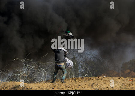 Gazastreifen. Dezember 15, 2017 - Auseinandersetzungen zwischen palästinensischen Demonstranten und israelischen Soldaten in der Nähe der Gaza-Israel Grenzzaun auszubrechen, östlich von al-Bureij palästinensischen Flüchtlingslager, nach Freitag mittag Gebete. Die Palästinenser Demonstranten, die auf dem jüngsten UNS' Anerkennung Jerusalems als Hauptstadt Israels verärgert, warfen Steine auf die israelischen Kräfte, die an ihnen feuerte Tränengas und scharfer Munition. Eine Reihe von Palästinensern Demonstranten berichtet wurden bei den Unruhen verletzt. Credit: ZUMA Press, Inc./Alamy leben Nachrichten Stockfoto