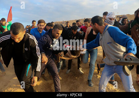 Gazastreifen. Dezember 15, 2017 - Auseinandersetzungen zwischen palästinensischen Demonstranten und israelischen Soldaten in der Nähe der Gaza-Israel Grenzzaun auszubrechen, östlich von al-Bureij palästinensischen Flüchtlingslager, nach Freitag mittag Gebete. Die Palästinenser Demonstranten, die auf dem jüngsten UNS' Anerkennung Jerusalems als Hauptstadt Israels verärgert, warfen Steine auf die israelischen Kräfte, die an ihnen feuerte Tränengas und scharfer Munition. Eine Reihe von Palästinensern Demonstranten berichtet wurden bei den Unruhen verletzt. Credit: ZUMA Press, Inc./Alamy leben Nachrichten Stockfoto