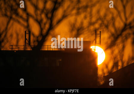 Merton, London, UK. 16. Dezember, 2017. Sonne hinter Gebäude in South West London mit klaren Frosty am frühen Morgen Himmel. Credit: Malcolm Park/Alamy leben Nachrichten Stockfoto